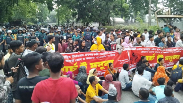 বৃষ্টিতে ভিজেই বেতনের দাবিতে পোশাকশ্রমিকদের বিক্ষোভ
